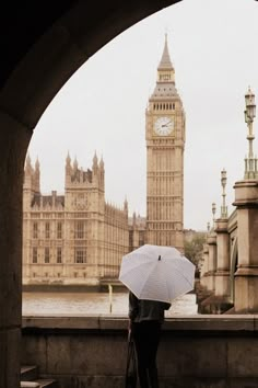 a person with an umbrella looking at the big ben clock tower