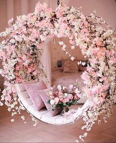 a circular mirror with pink flowers hanging from it's sides in a living room