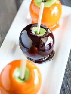 three caramel apples on a white plate