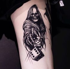 a person with a skull and dice tattoo on their arm, holding a dice in one hand