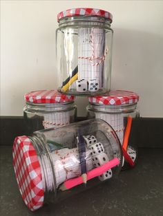 four glass jars with dices and pencils in them