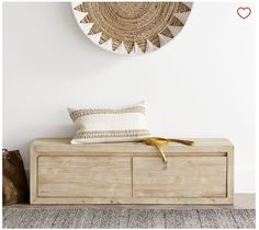 a wooden bench with a pillow on top of it next to a wall mounted clock