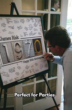 a man is writing on a sign in front of him