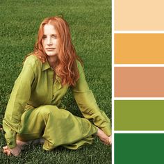 a woman is sitting in the grass with red hair and green eyeshadow on her face