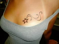 a woman with a star tattoo on her chest and the word love is written in cursive writing