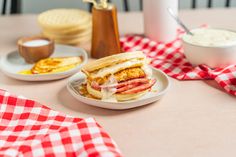 two plates with sandwiches on them sitting on a table