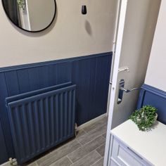 a bathroom with a radiator, sink and mirror on the wall next to it