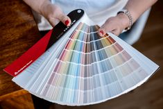 a person holding a pan with different shades of paint swatches in their hands,