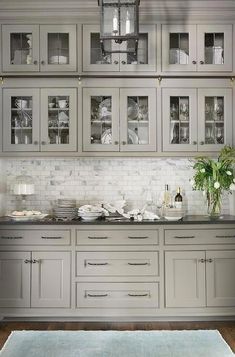 a kitchen with gray cabinets and white counter tops