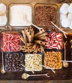 an assortment of candies and marshmallows in containers