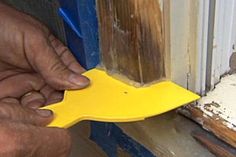 a person is using a plastic tool to fix a window