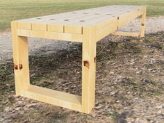 a wooden bench sitting on top of a grass covered field next to a dirt road