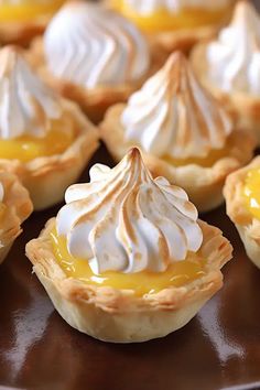 there are many small pies on the plate together and one is topped with meringue