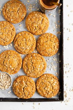 oatmeal cookies are arranged on a baking sheet next to a cup of tea