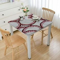 a dining room table with baseballs on it and two chairs in front of the table