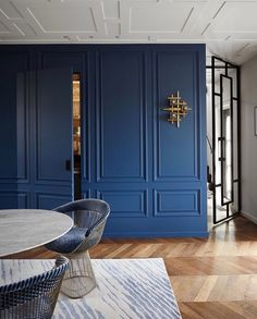 a dining room with blue walls and wooden floors