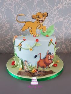 the lion king birthday cake is decorated with fondant and edible leaves, flowers, and characters