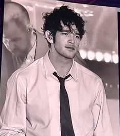 black and white photograph of young man in dress shirt and tie looking to the side