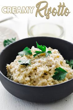 a black bowl filled with rice and garnished with parsley on the side