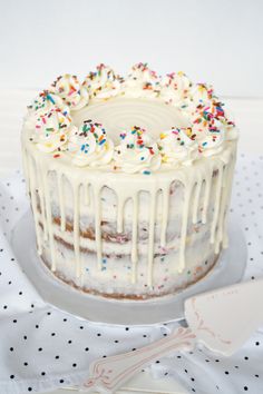 a cake with white frosting and sprinkles