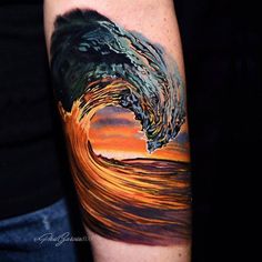 a man's arm with a colorful wave tattoo on it