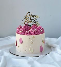 a birthday cake with pink and white frosting