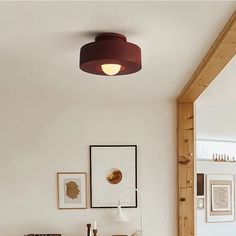 a living room filled with furniture and pictures on the wall next to a lamp fixture