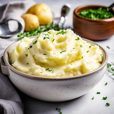 mashed potatoes in a bowl with parsley on the side