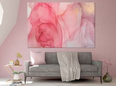 a living room with pink walls and a large painting hanging on the wall above it