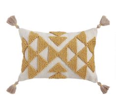 a yellow and white pillow with tassels on the front, sitting against a white background