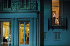 two people standing on the balcony of a building at night