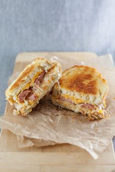 a sandwich cut in half sitting on top of a wooden cutting board