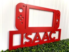 a red metal sign that says sasac on the side of a white wall next to green bushes