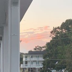 a cat sitting on top of a window sill looking out at the street below