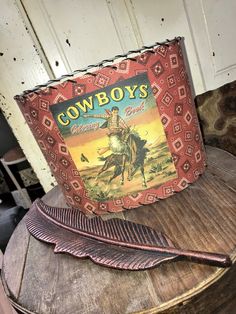 an old cowboy's book sitting on top of a wooden table next to a feather