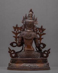 a bronze buddha statue sitting on top of a table