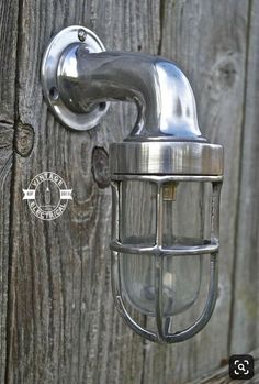 a metal light mounted on the side of a wooden fence