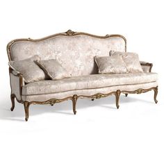 an old fashioned couch with pillows on it's back and arm rests against a white background