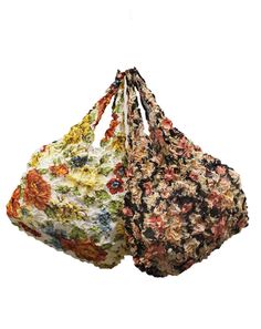 two bags with floral print on them hanging from the side, one has a drawstring