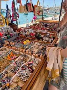 a woman standing in front of a table filled with lots of different types of items