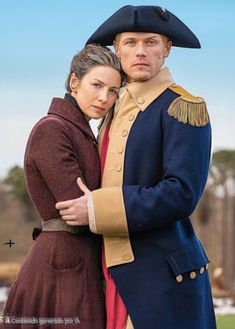 a man and woman dressed in period clothing posing for a photo with the sky behind them