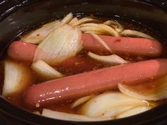 hot dogs and onions cooking in a slow cooker