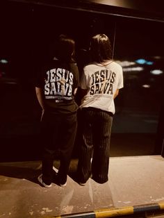 two people standing in front of a window with the words jesus and savi written on it