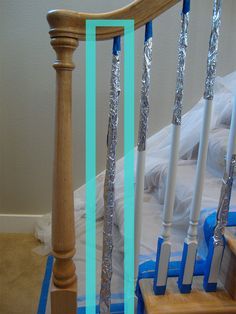 a wooden banister with blue tape on it and some white railings in the background