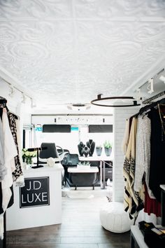 the inside of a clothing store with clothes hanging on racks