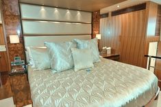 a bed with four pillows on it in a room that has wood paneling and white walls