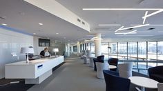 a woman sitting at a desk with a laptop in an empty office space that is well lit