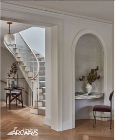 an arch in the hallway leads to a dining room and living room area with stairs