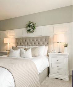 a white bed sitting next to two lamps on either side of the headboard and foot board