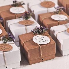 several boxes with tags tied to them and some flowers in the middle one has a name tag on it